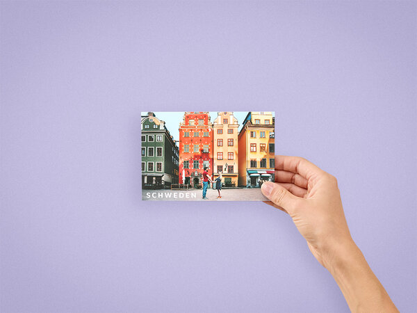 Ein querformatiges Fotobuch im Format 10x15 cm wird in der Hand gehalten. Auf dem Cover ist ein Paar in Stockholm abgebildet.